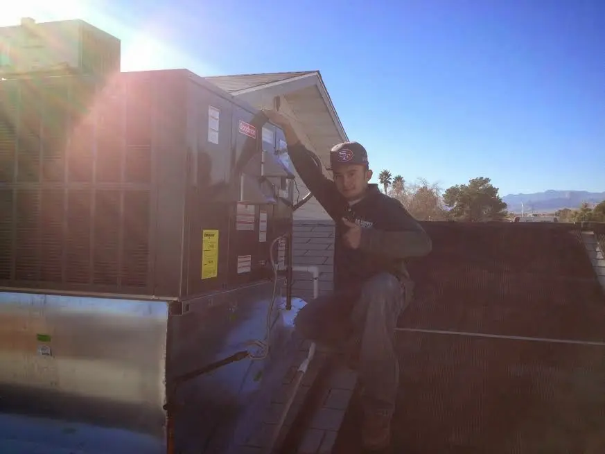 HVAC technician performing HVAC Inspection on a rooftop unit in Girard